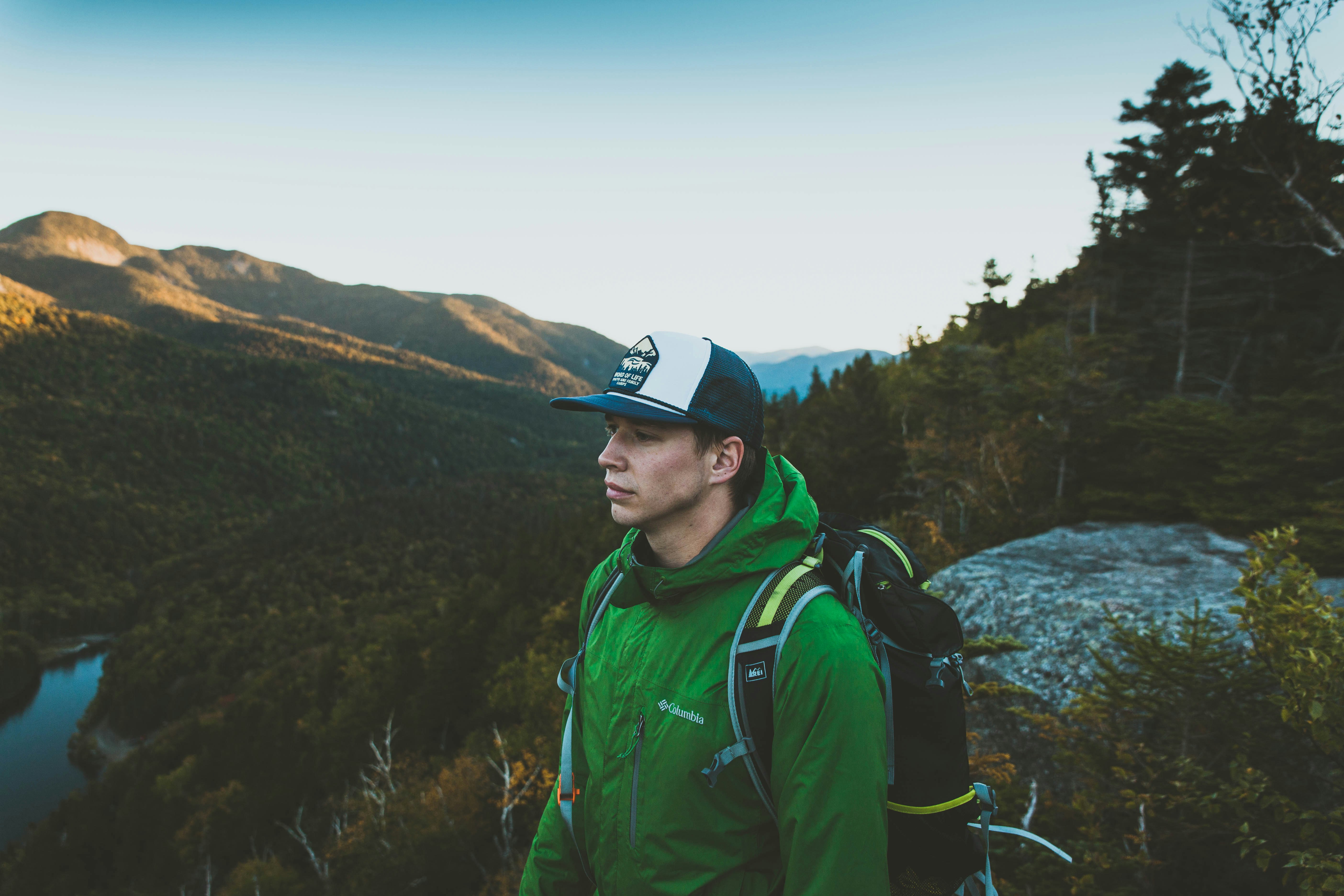 man in green jacket in forest during daytime